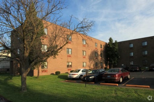 a large brick building with cars parked in a parking lot