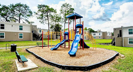 A playground with a blue slide and a yellow and blue play structure.