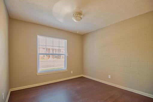 Empty room with a window and a ceiling fan.