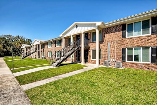 A row of houses with green lawns in front.
