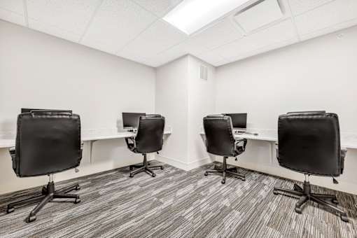 a room with four desks and leather chairs