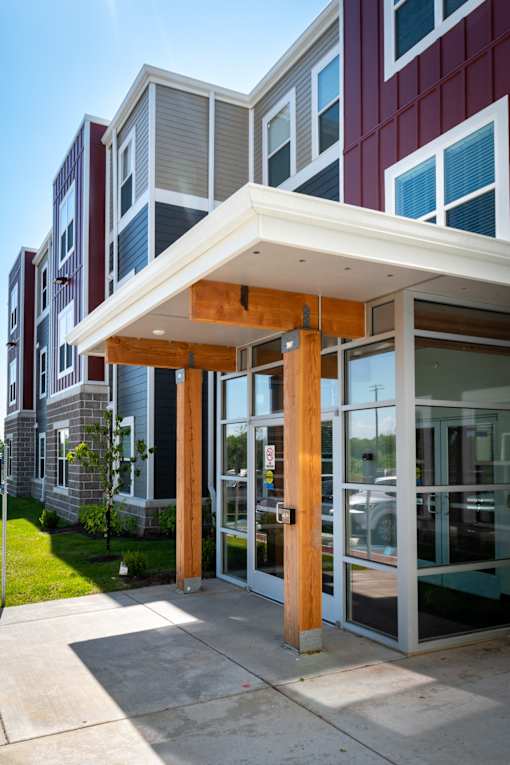 a view of the front of a building with glass doors and a porch