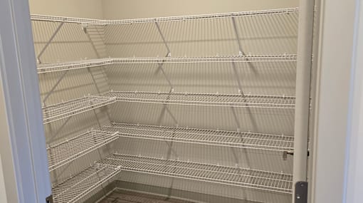 Empty shelves in a white refrigerator.