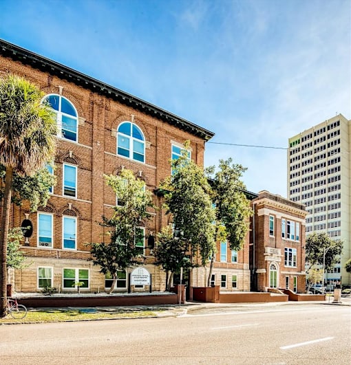 A red brick building with a green lawn in front.