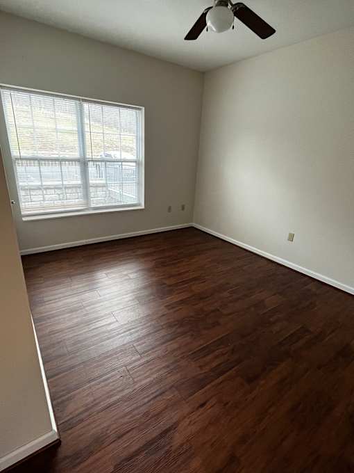 A room with a ceiling fan and a window.