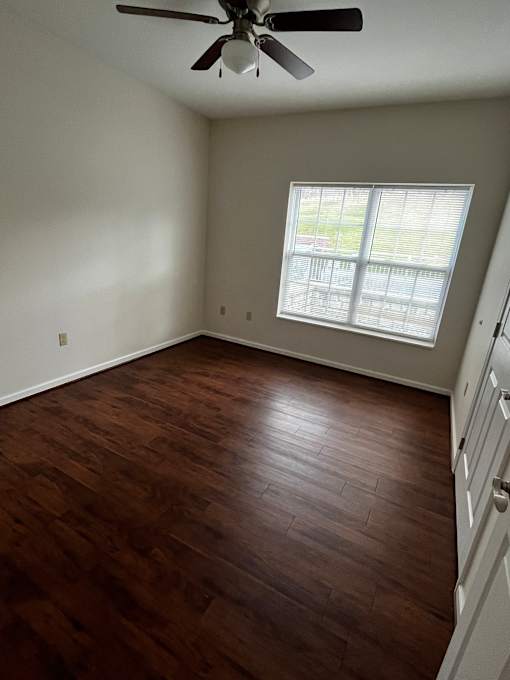 A room with a ceiling fan and a window.