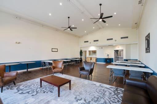 a large room with tables and chairs and a lounge area