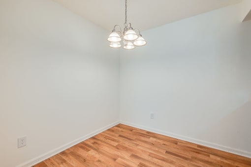a bedroom with a wood floor and white walls