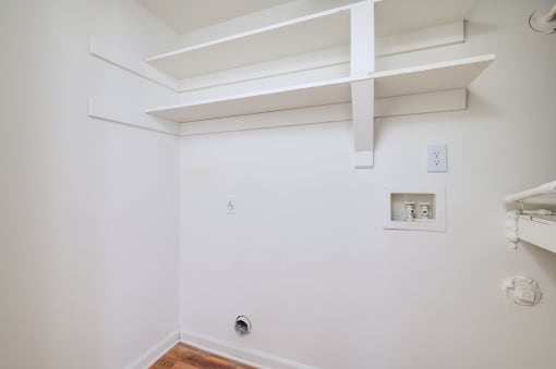 a white room with a white wall and a white shelf on top of it