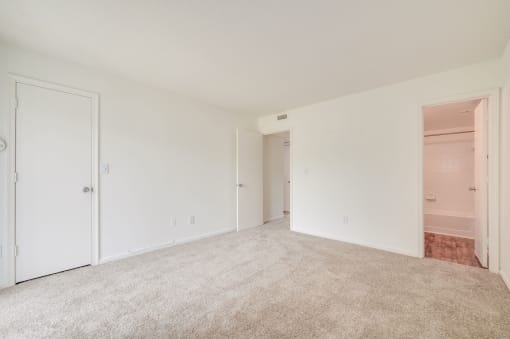 a bedroom with a carpeted floor and a door to a closet