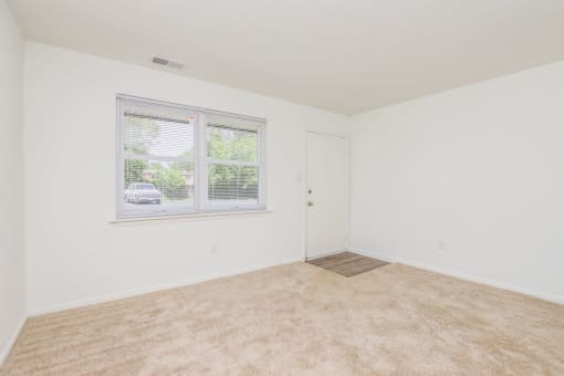 a bedroom with a large window and white walls