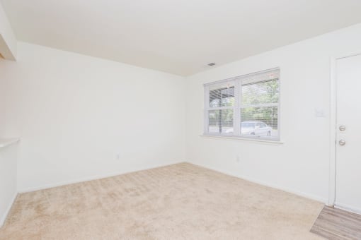 a bedroom with a large window and white walls