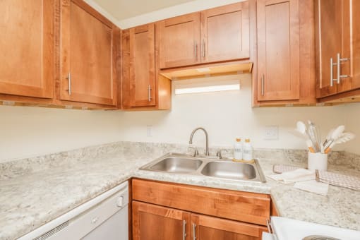 a kitchen with wood cabinets and granite counter tops and a sink