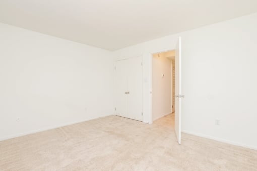 an empty room with a door open to a closet