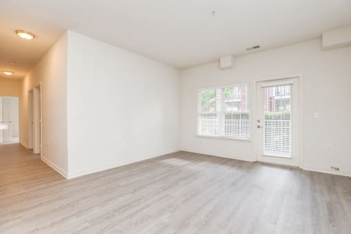 an empty living room with white walls and wood flooring