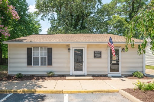 a small white house with an flag in front of it