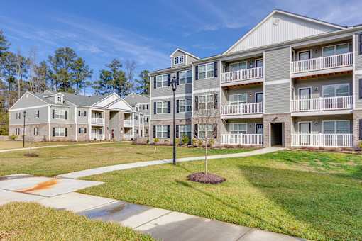 Apartment complex with a tree in front of it.