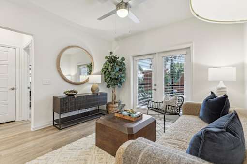 a living room with french doors and ceiling fan at Tapestry Headwaters in Kissimmee, FL