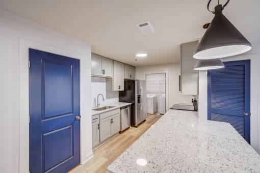 a renovated kitchen with blue doors and white cabinets