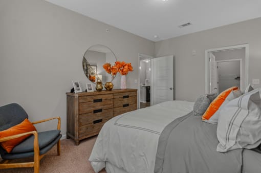 a bedroom with a bed and a dresser and a mirror