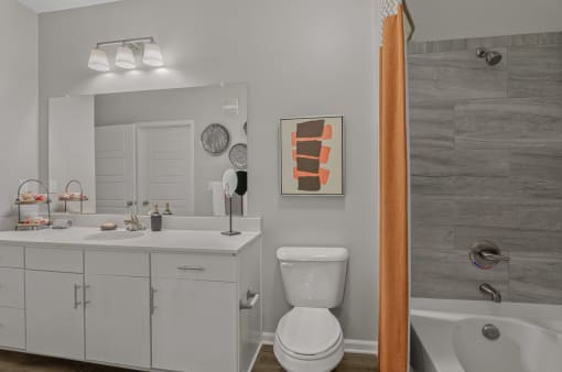 a bathroom with vanity, toilet and tub