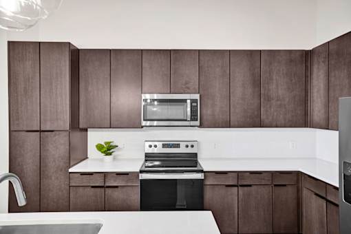 A modern kitchen with dark wood cabinets and white countertops.