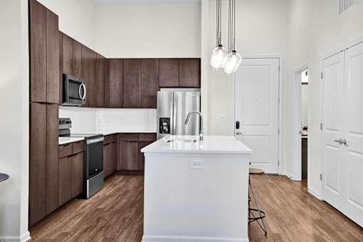 A modern and chef style kitchen with brown cabinets and a white island.