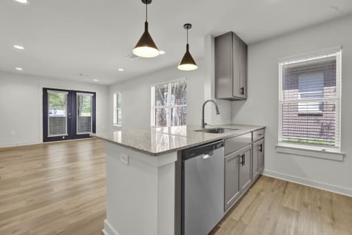 an open kitchen and living room with a large counter top