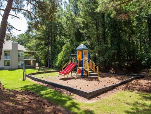 the playground is in the middle of a yard with a slide