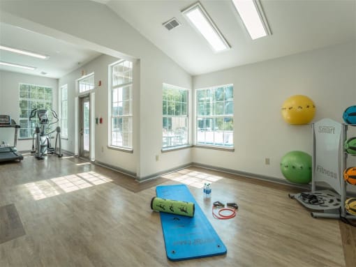 a workout room with yoga mats and a gym ball on the wall