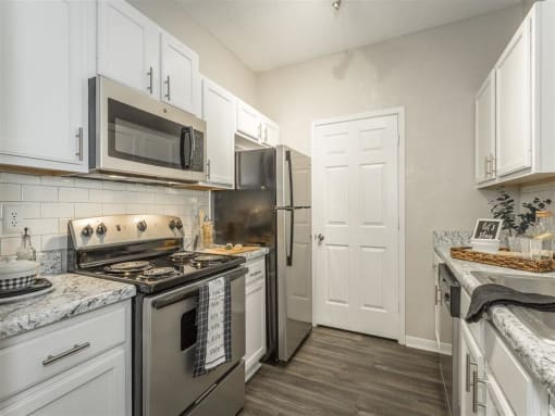 a kitchen with stainless steel appliances and white cabinets