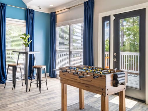 a game room with a foosball table and a patio