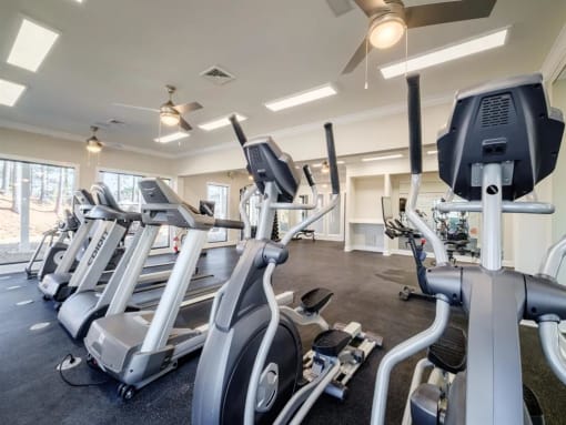 a gym with various cardio machines and weights