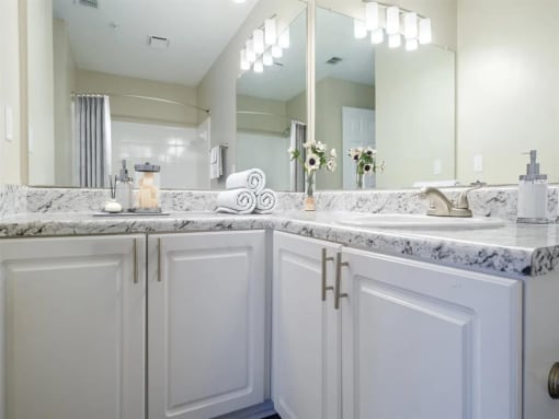 a bathroom with white cabinets and a sink and a mirror