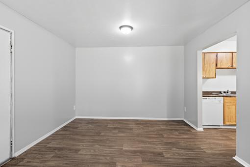 A room with a white wall and a wooden floor.