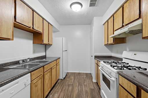 A kitchen with wooden cabinets and white appliances.
