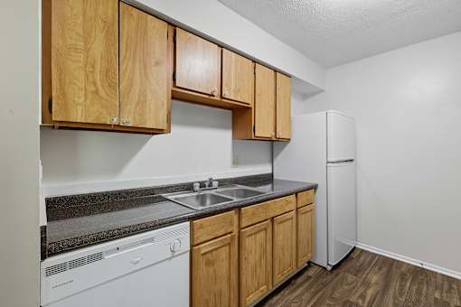 A kitchen with wooden cabinets and a white dishwasher.