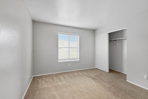 A room with a window and carpeted floor.