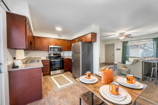 a kitchen and dining area with wooden cabinets and stainless steel appliances  at Retreat at Brightside Apartments in Baton Rouge, LA