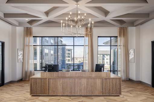 A reception area with a wooden desk and a chandelier.