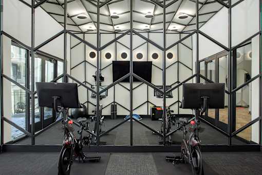A room with a black and white geometric patterned wall and two stationary bikes.