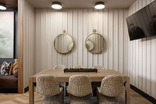 A dining room with a wooden table and chairs.
