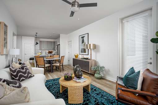 A living room with a white couch, a wooden coffee table, and a ceiling fan.