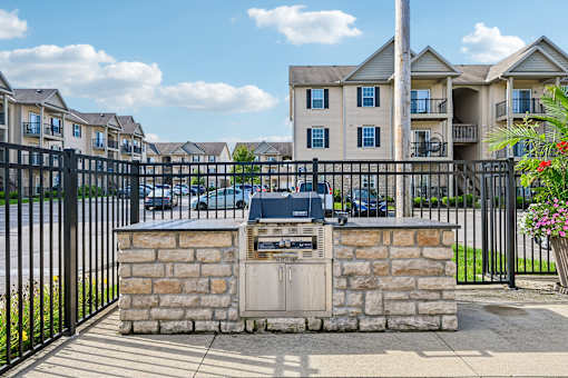A brick mailbox sits in front of a black metal fence.