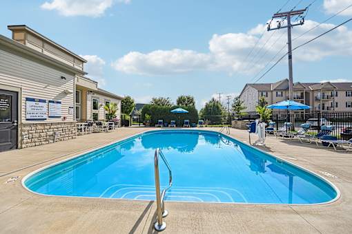 A large outdoor swimming pool with a diving board.