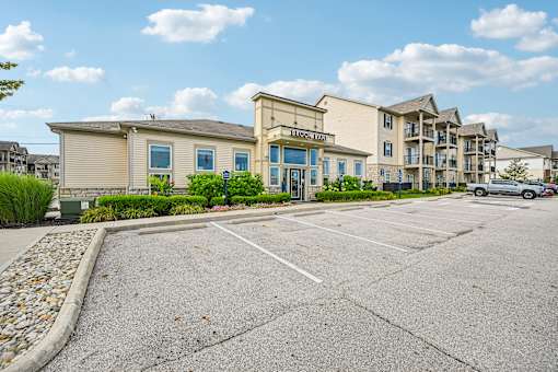 A parking lot in front of a building with a sign that reads "Heritage Lodge".