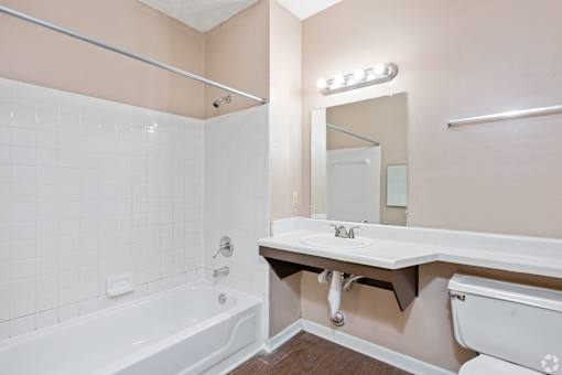 A bathroom with a white tub and sink.