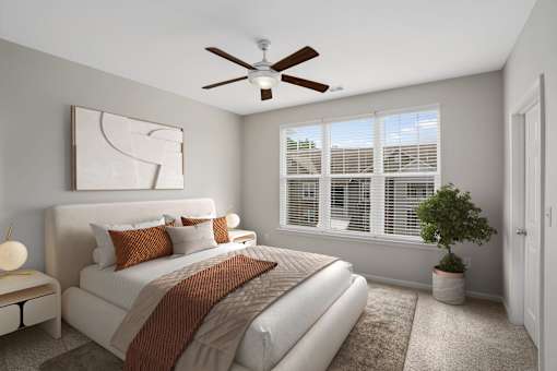 A bedroom with a large bed and a ceiling fan.