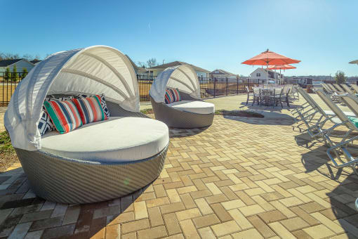 a patio with chairs and umbrellas at the enclave at woodbridge apartments in sugar land