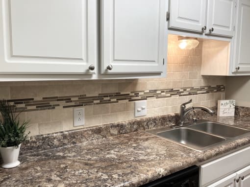 White kitchen cabinets and granite countertops at Malibu at Martin Apartments in Huntsville, Alabama